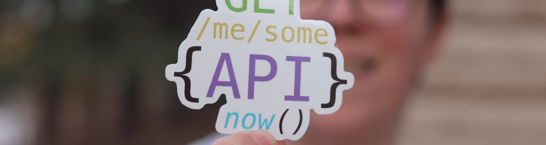 programmer holding a paper cutout with an api quote