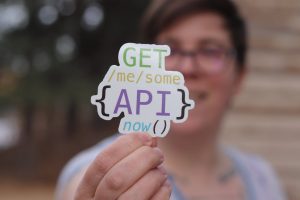 programmer holding a paper cutout with an api quote